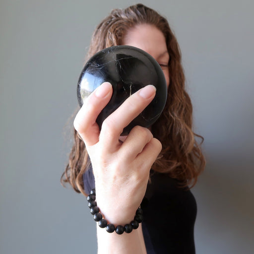 jamie of satin crystals  holding a black tourmaline sphere