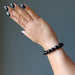 hand wearing faceted black tourmaline bracelet