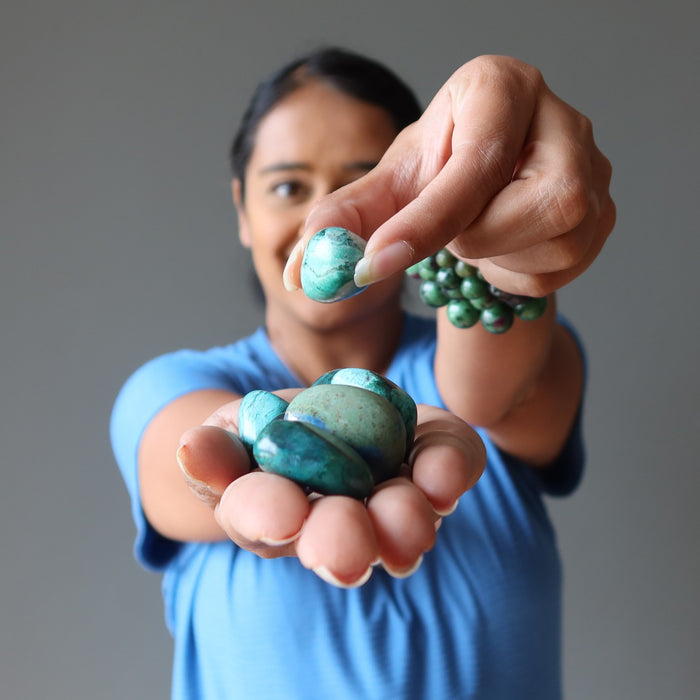 woman holding chrysocolla tumbled stones