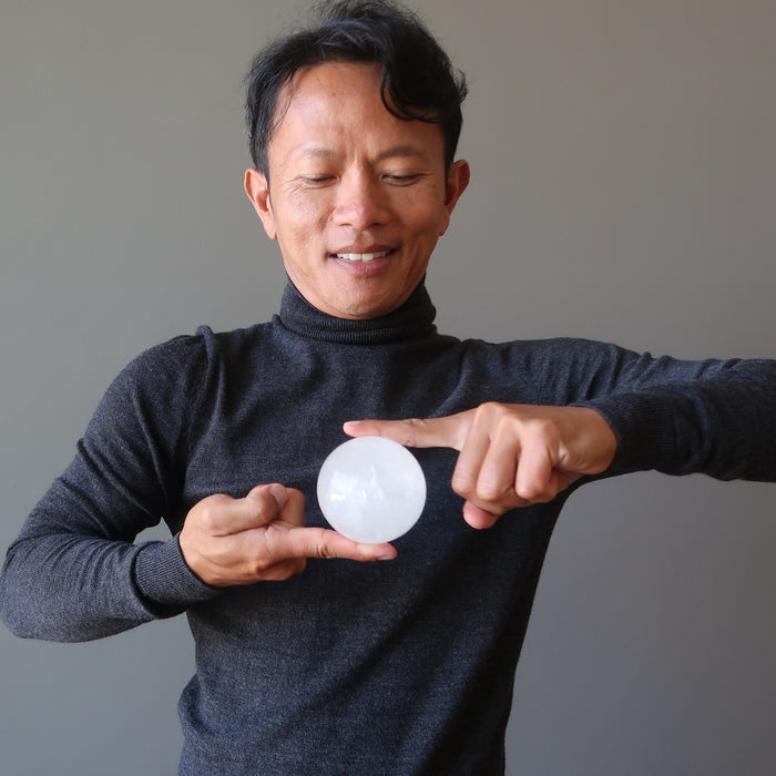 man holding a quartz crystal ball