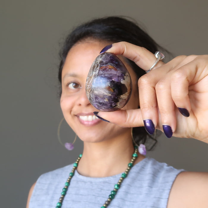 sheila of satin crystals holding up a purple amethyst egg