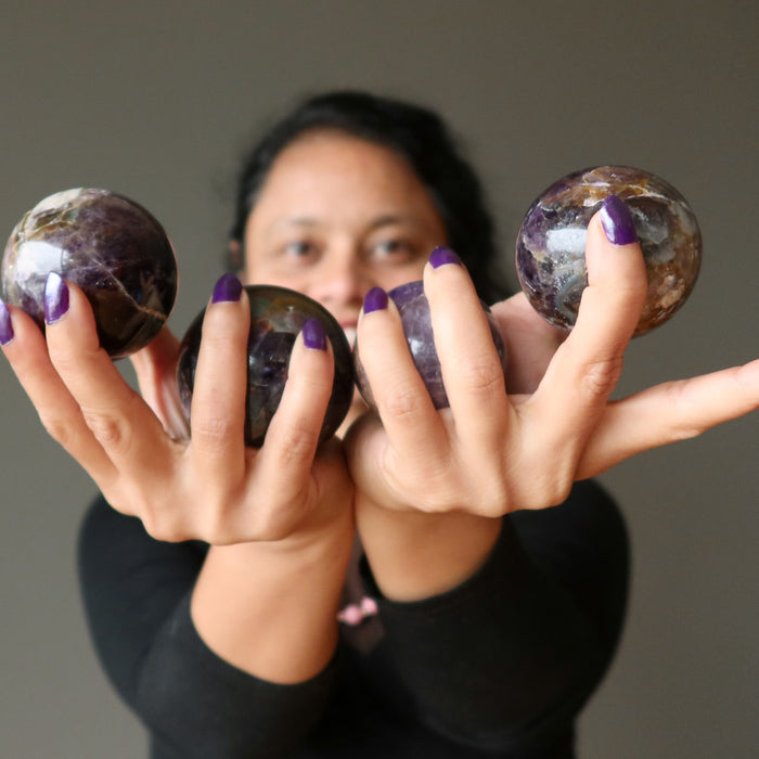sheila of satin crystals holding 4 amethyst spheres