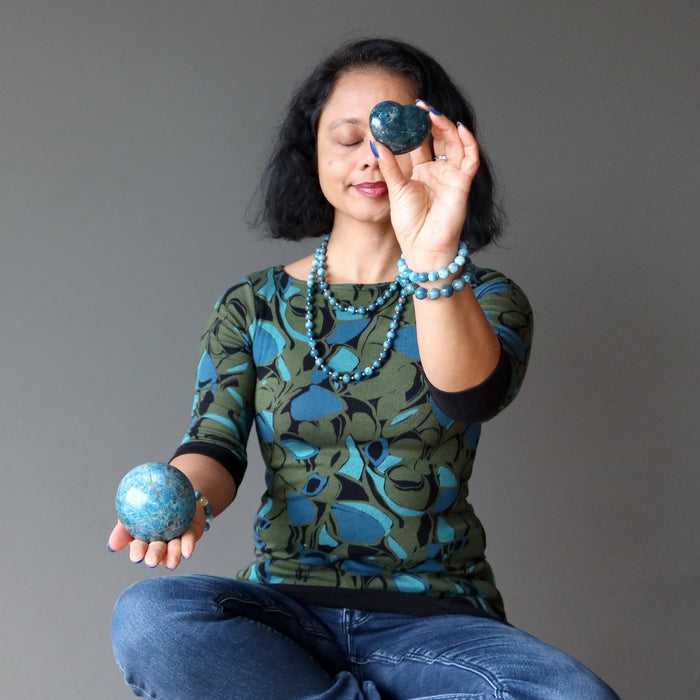 woman meditating with apatite heart and ball