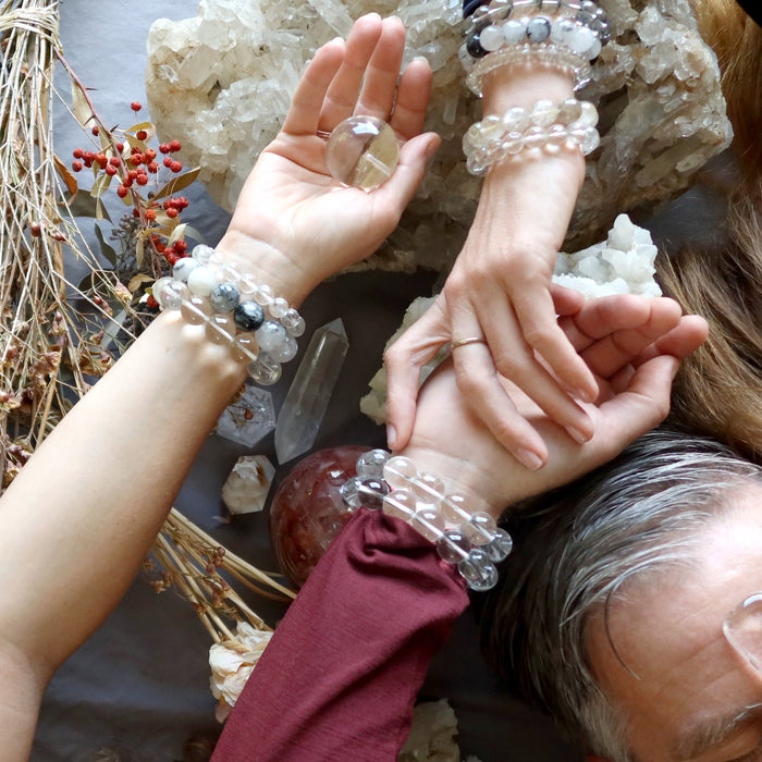 women and man's hands wearing quartz jewelry