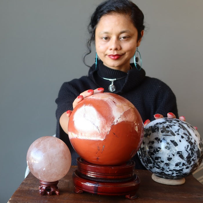 sheila of satin crystals sitting behind three large crystals balls for gazing