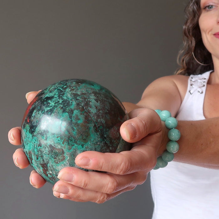 aleks of satin crystals holding out a chrysocolla crystal ball for earth healing