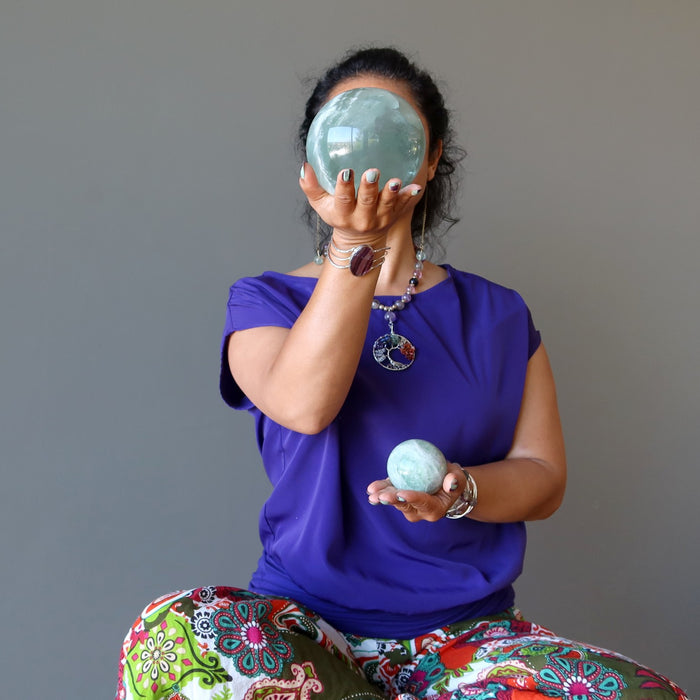 woman meditating with green fluorite spheres