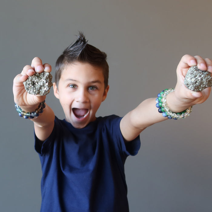 boy holding raw pyrite clusters