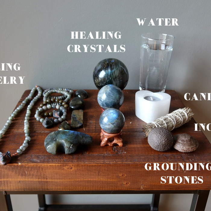 jewelry, crystals, water, candle, sage, grounding stones for meditation