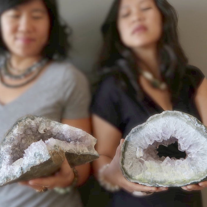 woman  meditating with two amethyst geodes