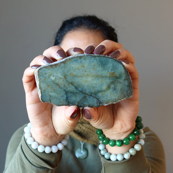 woman holding and wearing jade stones