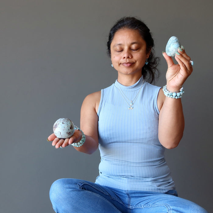 woman meditating with larimar sphere and egg