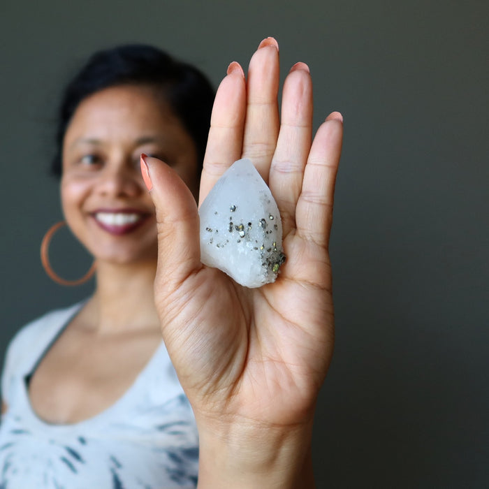 female model holding a quartz pyrite crystal in her palm