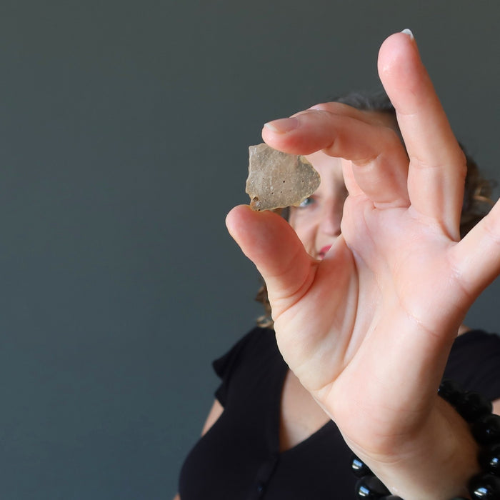 female holding up yellow libyan desert glass for affirmations