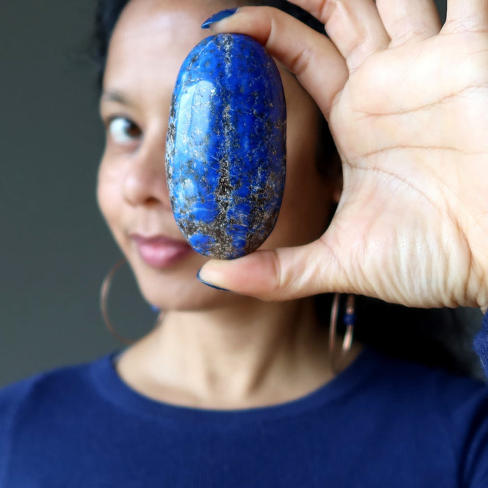sheila of satin crystals holding up a lapis palm stone