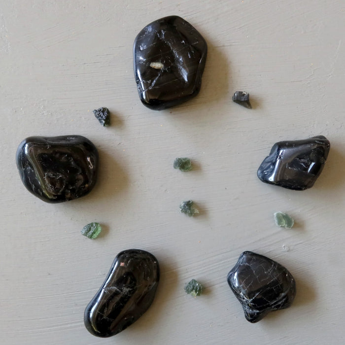 black tourmaline tumbled stones and raw moldavite