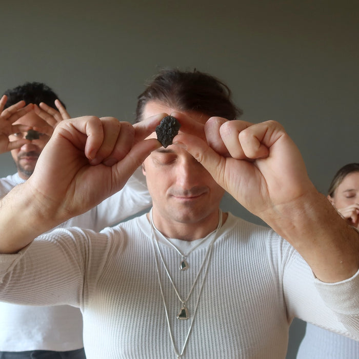 three people with moldavite at their foreheads