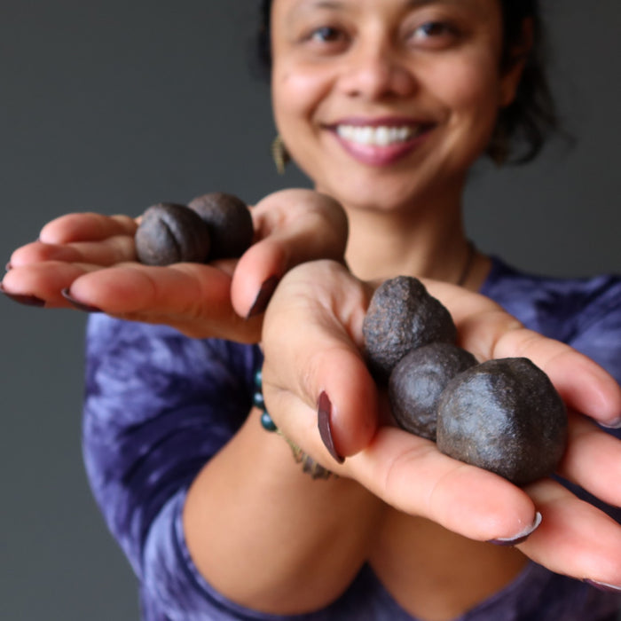 sheila of satin crystals holding 5 moqui marble stones in her hands
