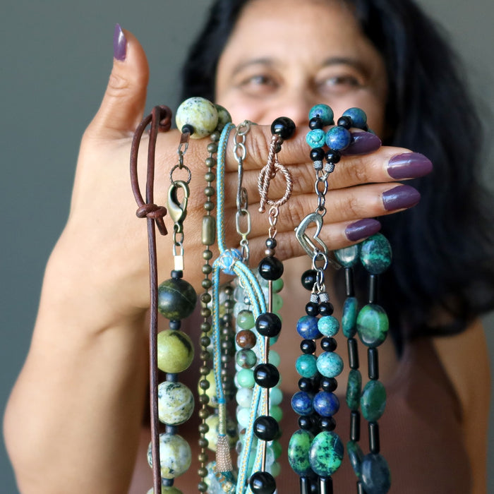 sheila of satin crystals holding different necklaces
