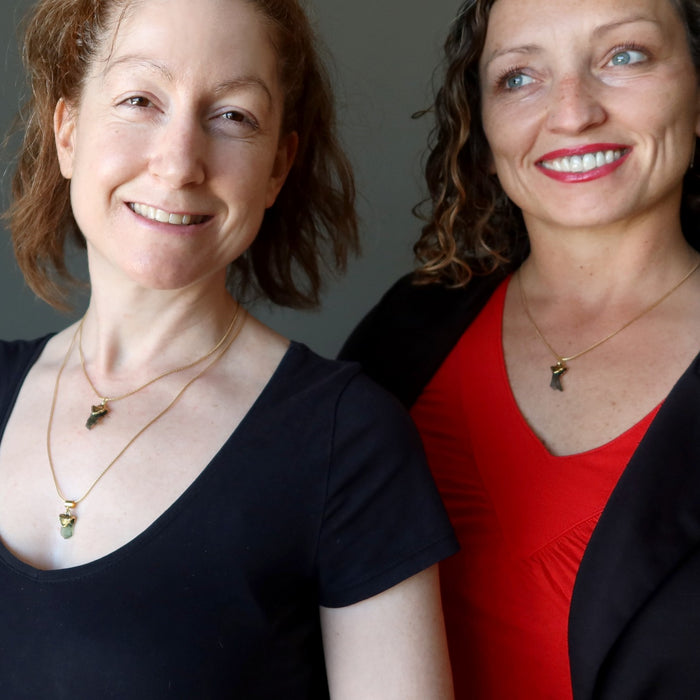 two women wearing moldavite pendants necklaces