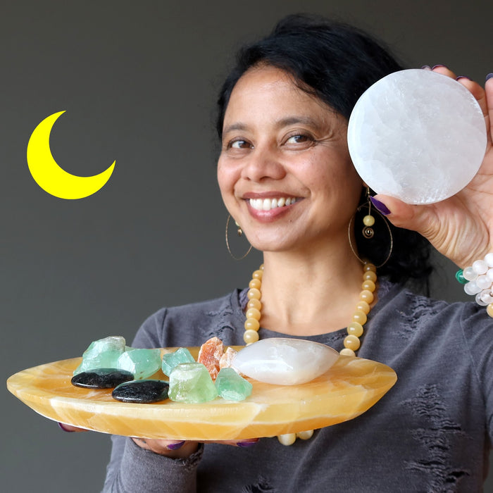 sheila of satin crystals holding selenite circle, wearing selenite bracelets, holding calcite platter