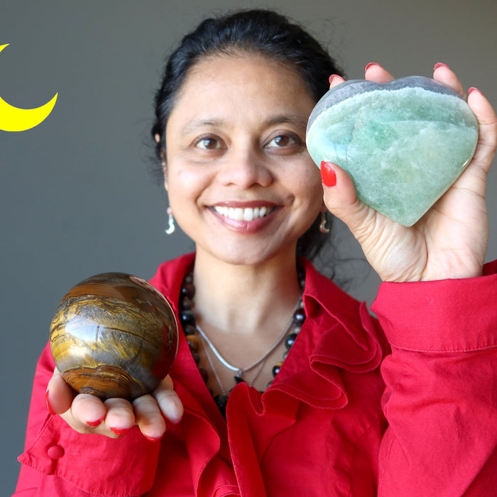 sheila of satin crystals holding a tigers eye sphere and green fluorite heart