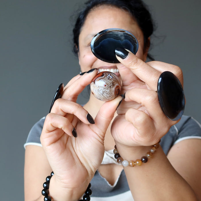 sheila of satin crystals holding and wearing sardonyx and onyx crystals