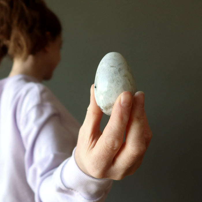 female holding a white moonstone egg