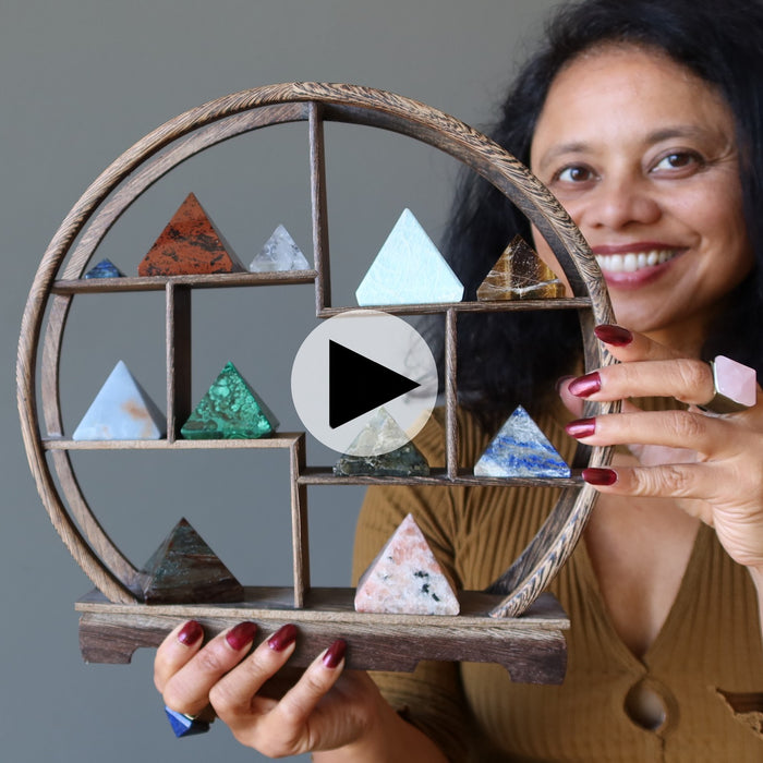 woman holding shelf of crystal pyramids