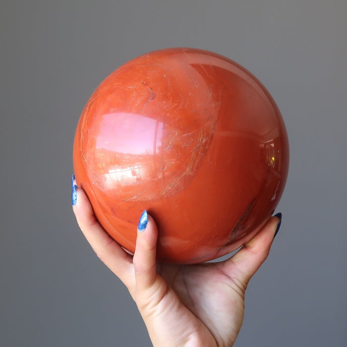 hand holding red jasper sphere