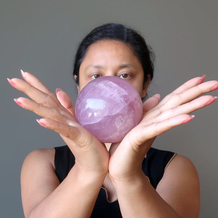 sheila of satin crystals gazing at a pink rose quartz sphere