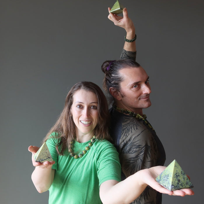 man and woman holding serpentine pyramids