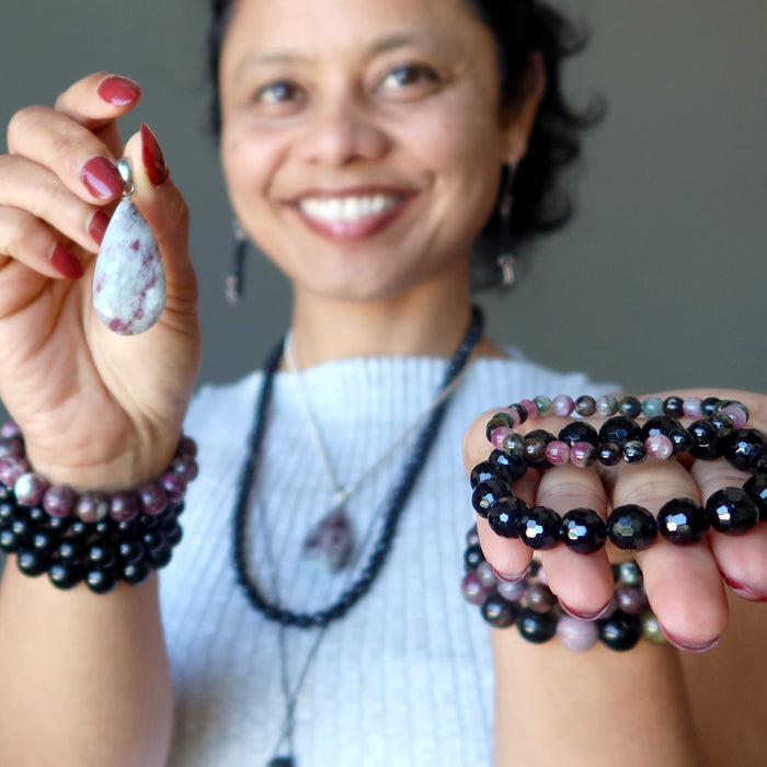 sheila of satin crystals wearing and holding tourmaline jewelry