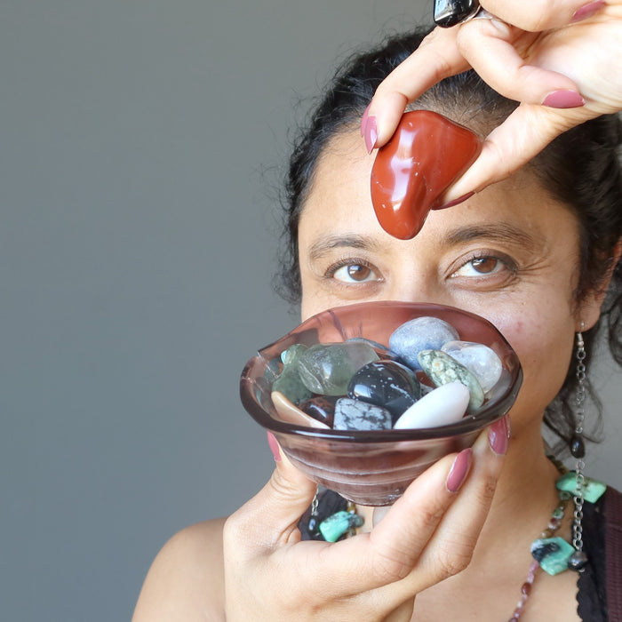 sheila of satin crystals holding a bowl of tumbled stones and a red jasper to her third eye