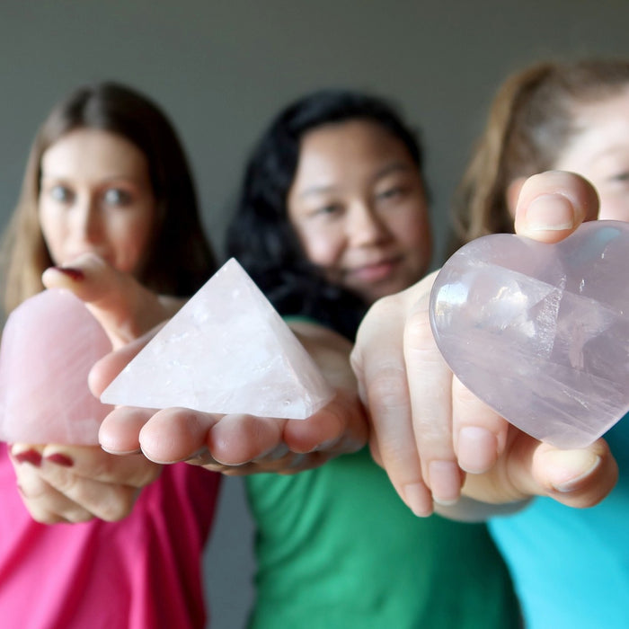 3 female models holding out rose quartz crystals