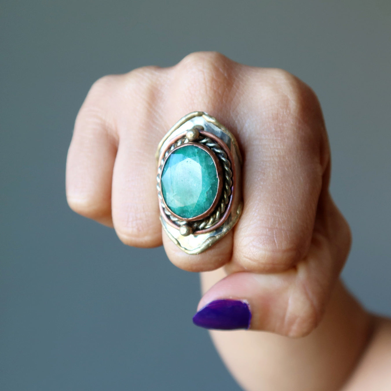 hand wearing emerald ring