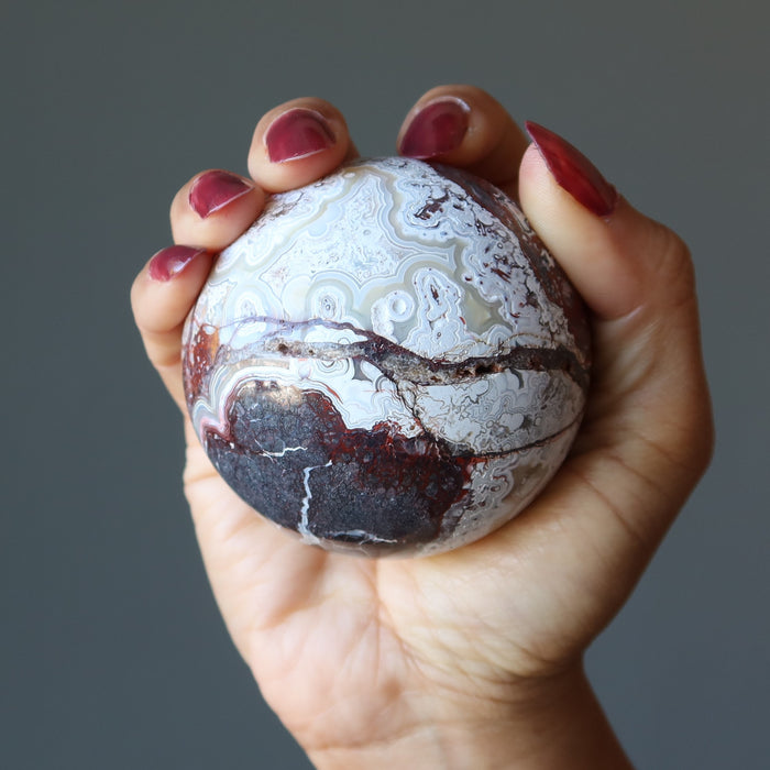 crazy lace agate sphere in hand