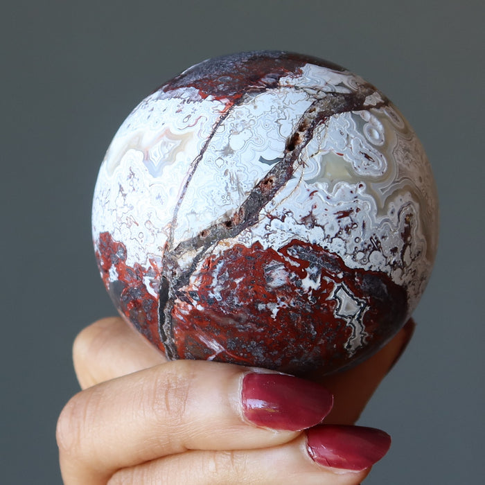 crazy lace agate sphere in hand