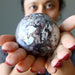 crazy lace agate sphere in hands