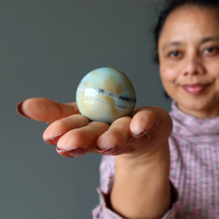 woman holding amazonite sphere