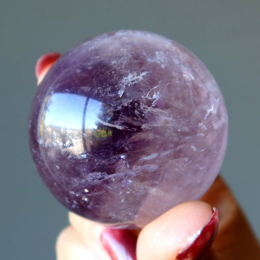 purple amethyst sphere in hand