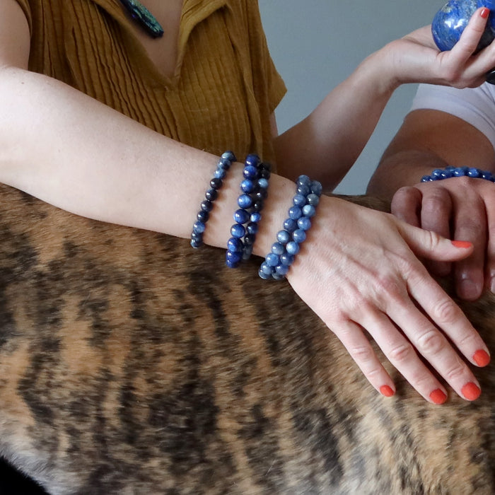 hand with stack of kyanite bracelets