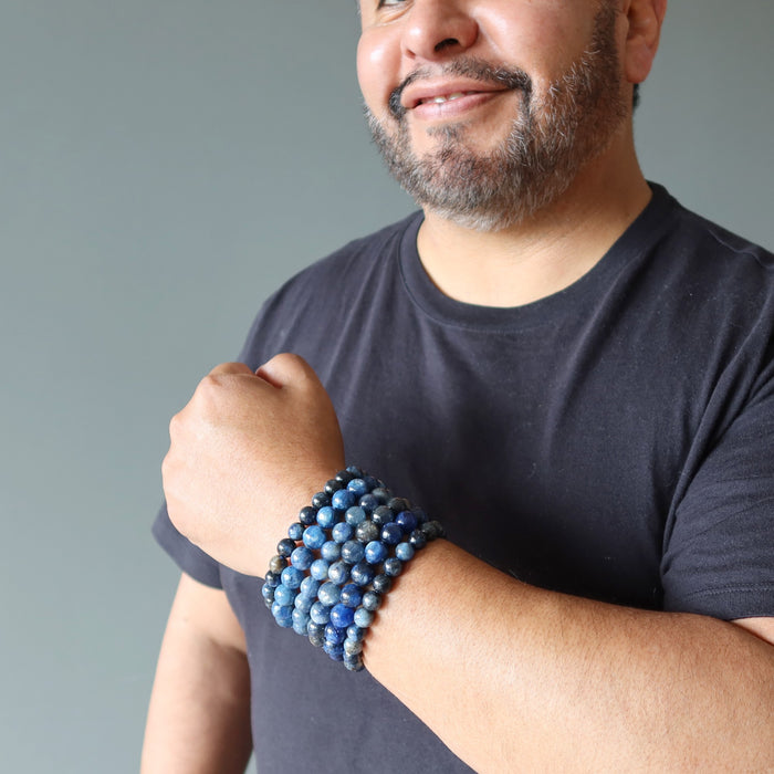 man wearing stack of kyanite bracelets