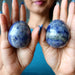 two denim lapis eggs in palms of hand