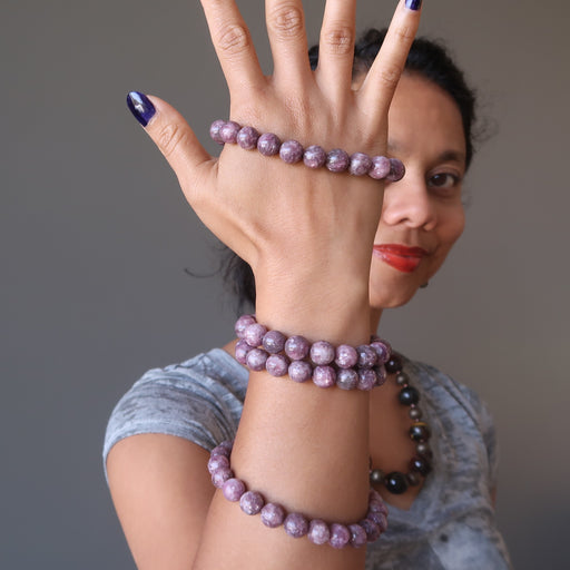 women wearing stack of lepidolite bracelets