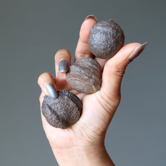 hand holding three moqui marbles