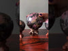 video on pink and black rhodonite sphere