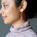 woman wearing rhodonite earrings