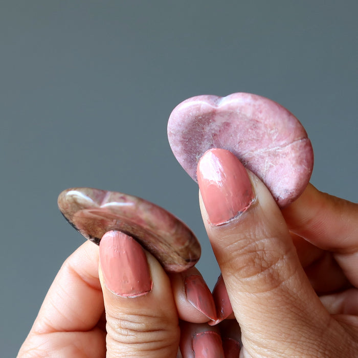 Holding two Pink Rhodonite Worry Stones