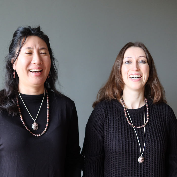 two women wearing rhodonite necklaces